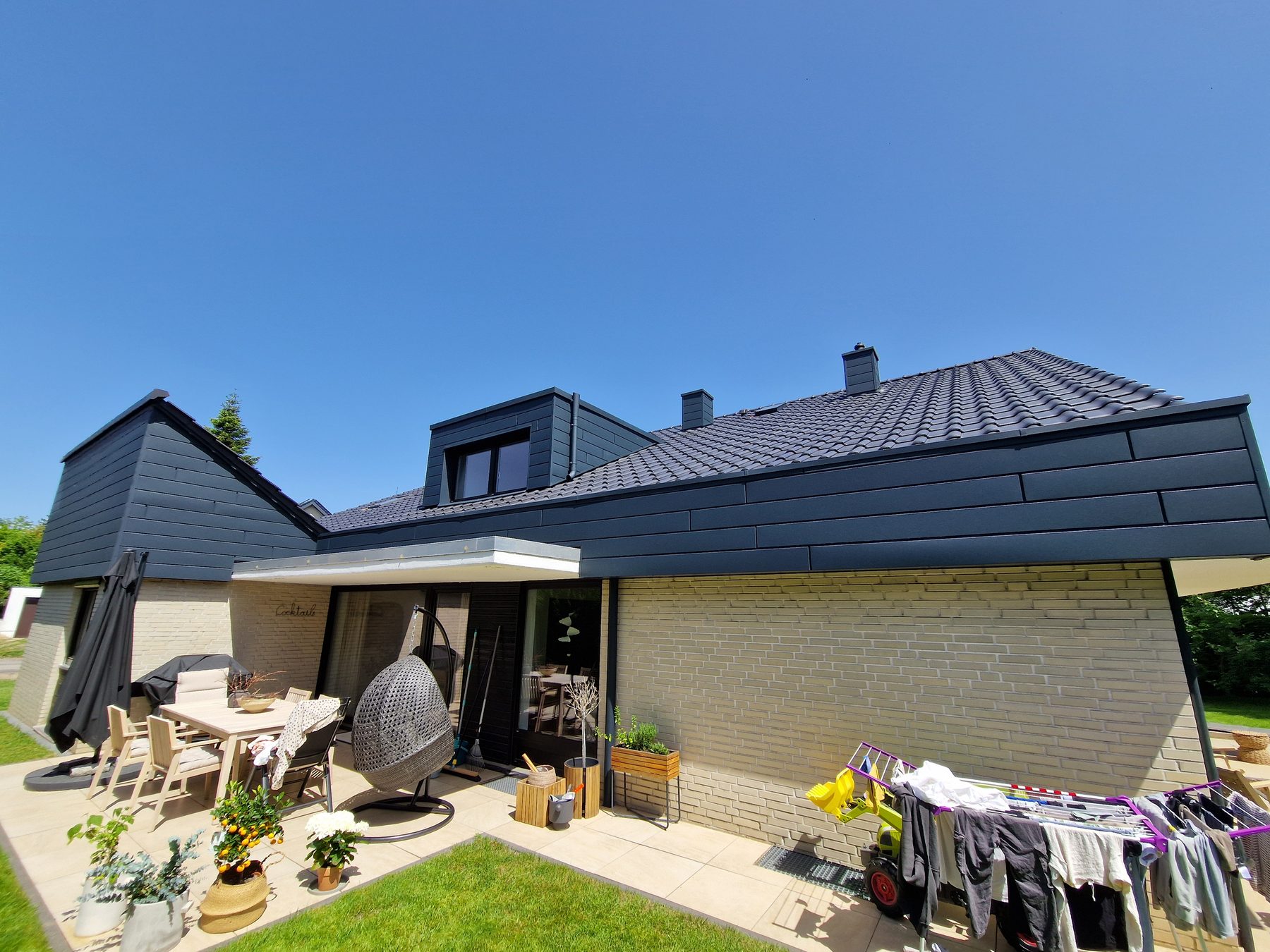 Gartenseite mit Terrasse und durchlaufender Dachfläche