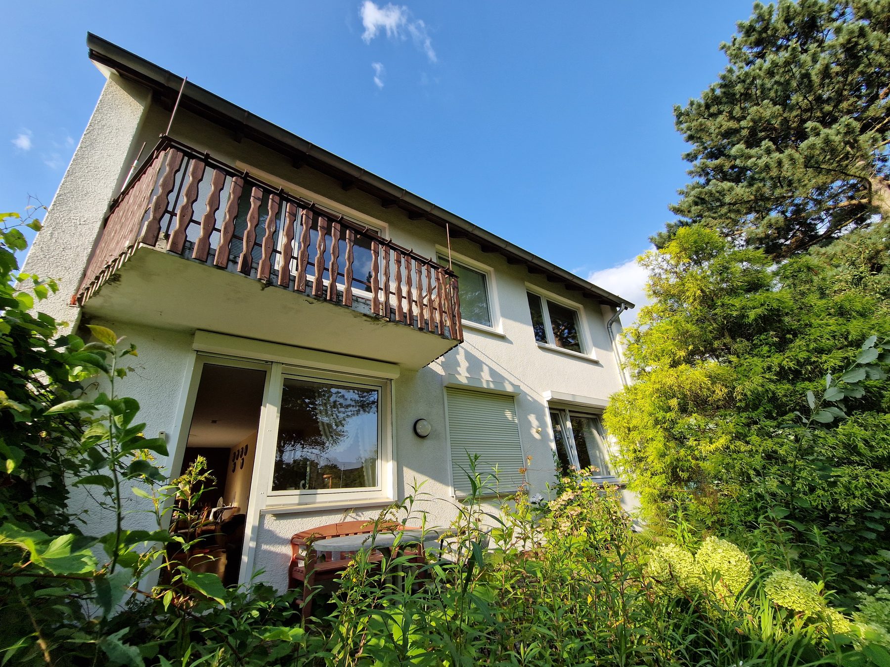 Vor der Sanierung: Gartenseite mit altem Holzbalkon